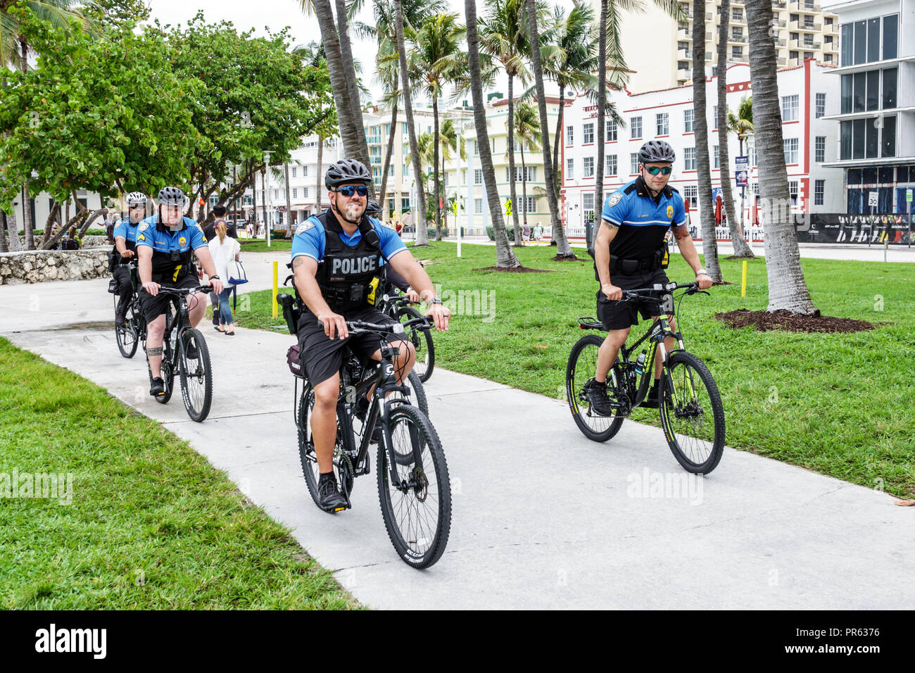 Miami Beach Florida,bicycle bicycles bicycling riding biking rider riders bike bikes,police patrol,officer officers,riding bicycles,FL180527201 Stock Photo