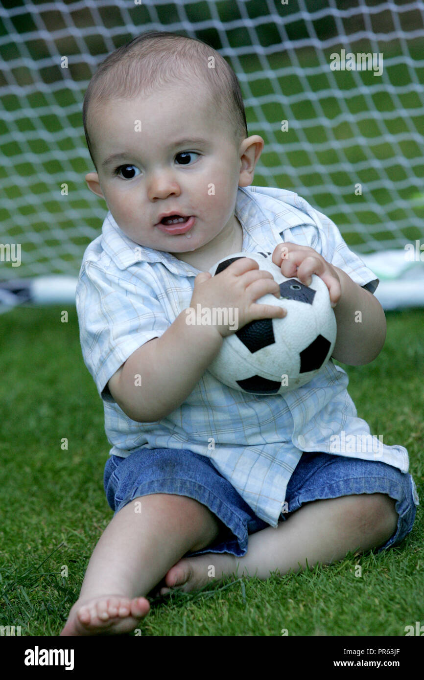 toddler playing with football Stock Photo