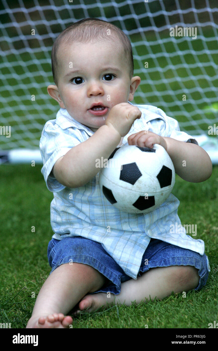 toddler playing with football Stock Photo