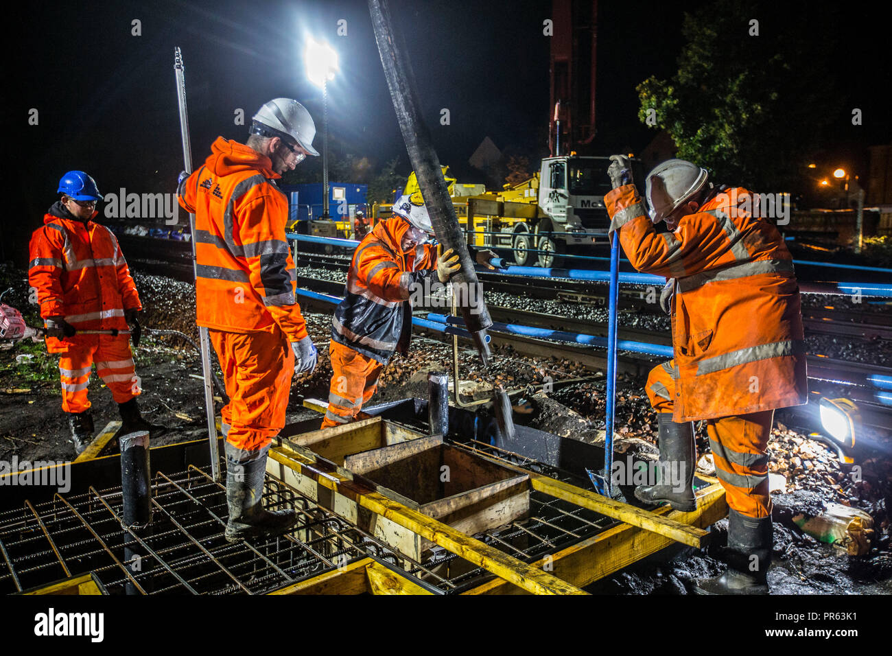 Railway construction workers pouring cement at night Stock Photo Alamy