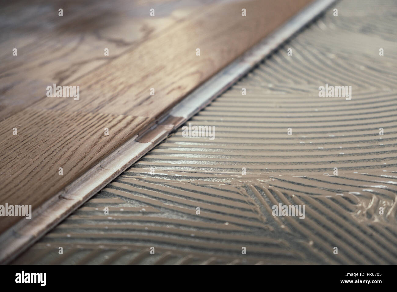 Laminated wooden boards installed on concrete floor with applied