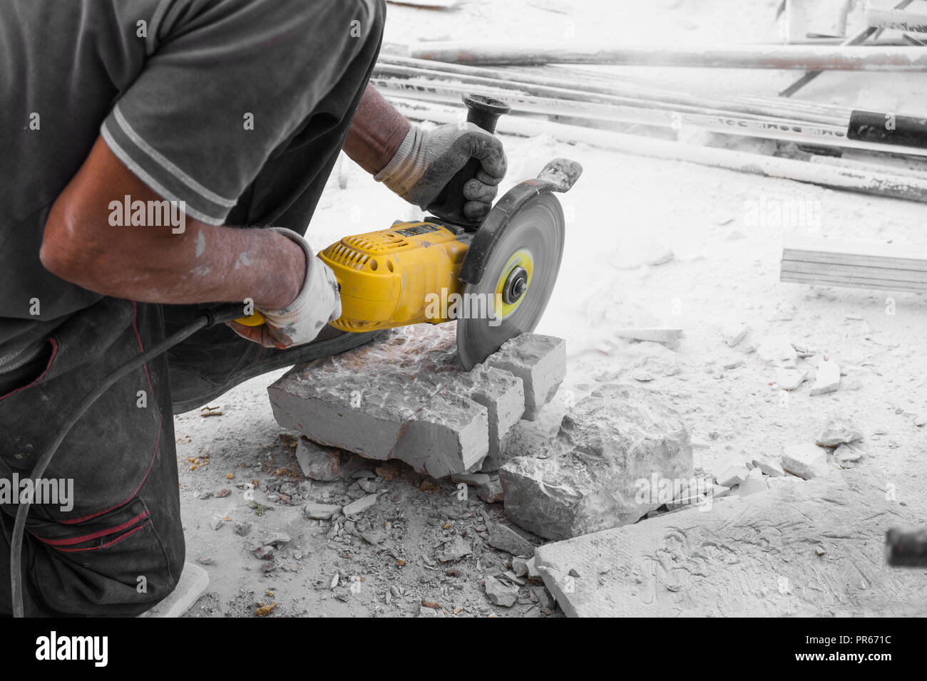 Worker cutting limestone block with power tool saw Stock Photo