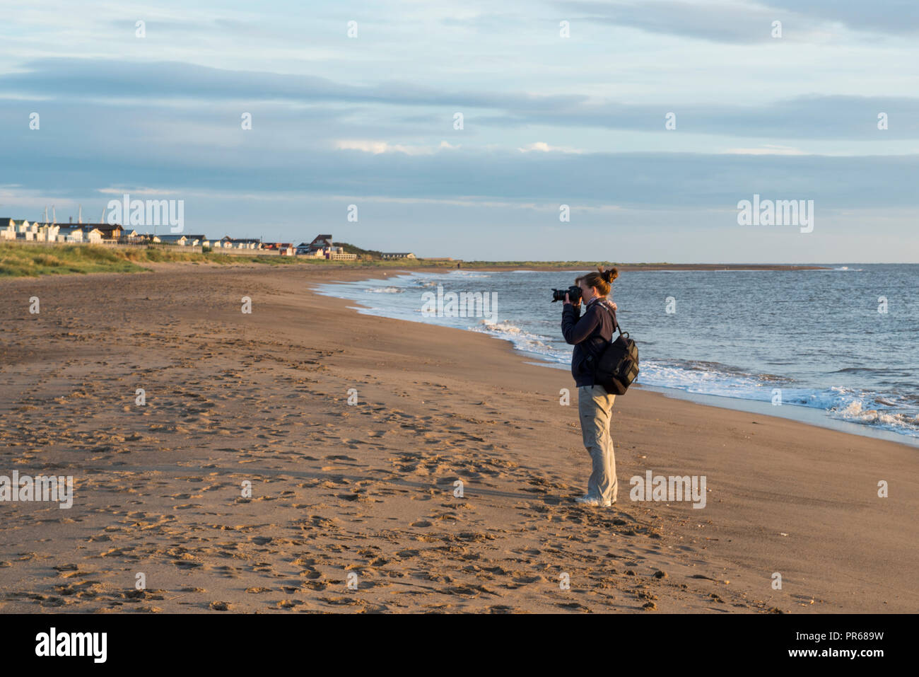 A photographer takes pictures in the early morning light at Winthorpe, near Skegness, UK Stock Photo