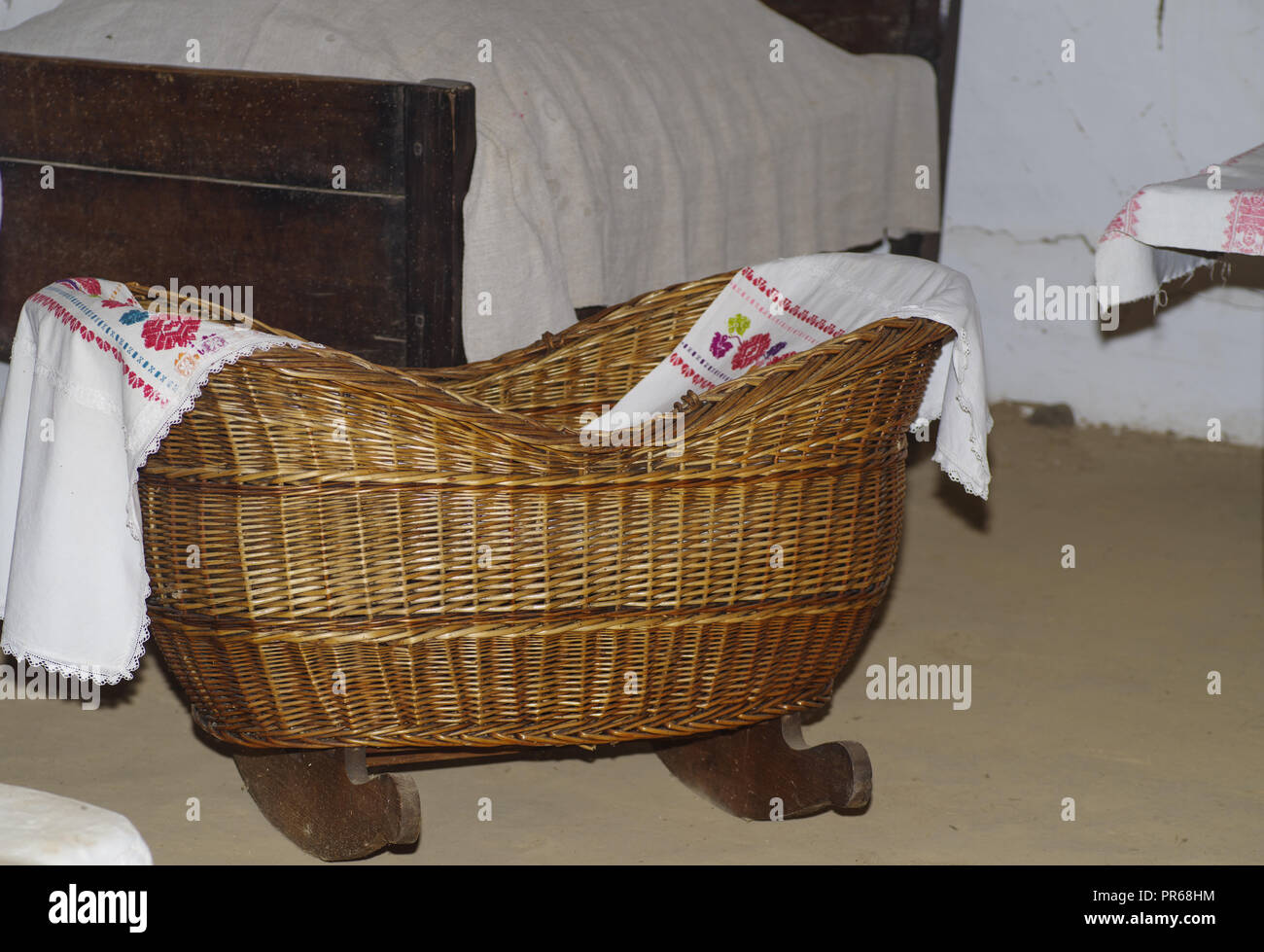 A small antique wooden cradle on wooden legs for a small baby.Old wooden cradle in village house Stock Photo