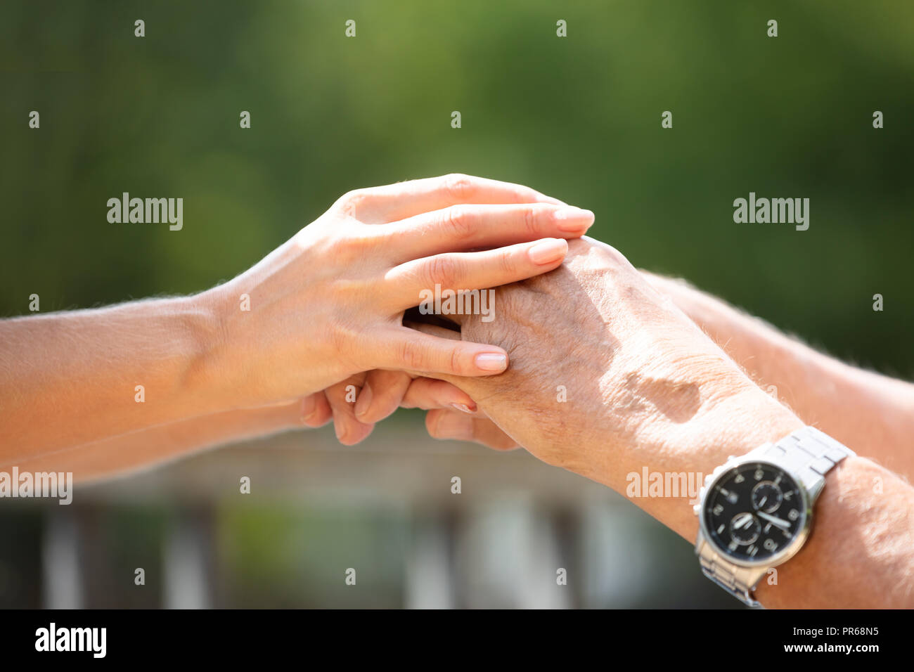 Close-up Of A Woman Holding Her Father's Hand At Outdoors Stock Photo
