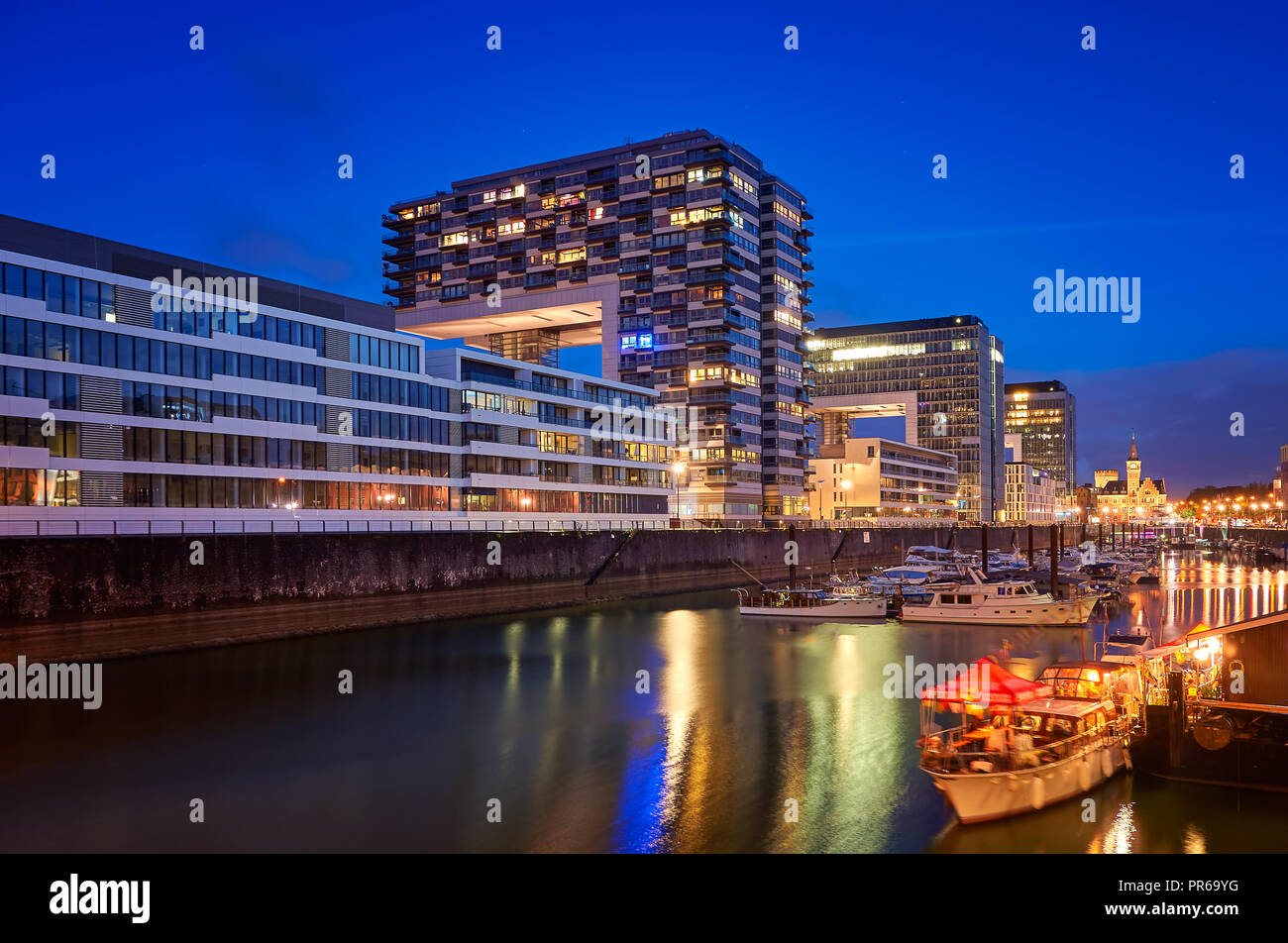 Rheinauhafen water promenade in Cologne Koeln marina at night with boats on the water Stock
