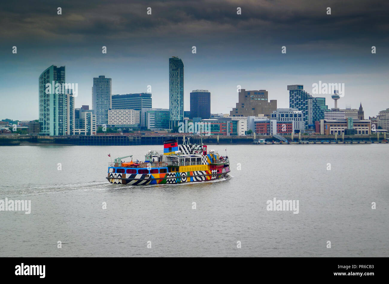 Mersey ferry Snowdrop, painted with Sir Peter Blake's Everybody Razzle Dazzle design, sails from Birkenhead towards Liverpool  Pier Head. Stock Photo