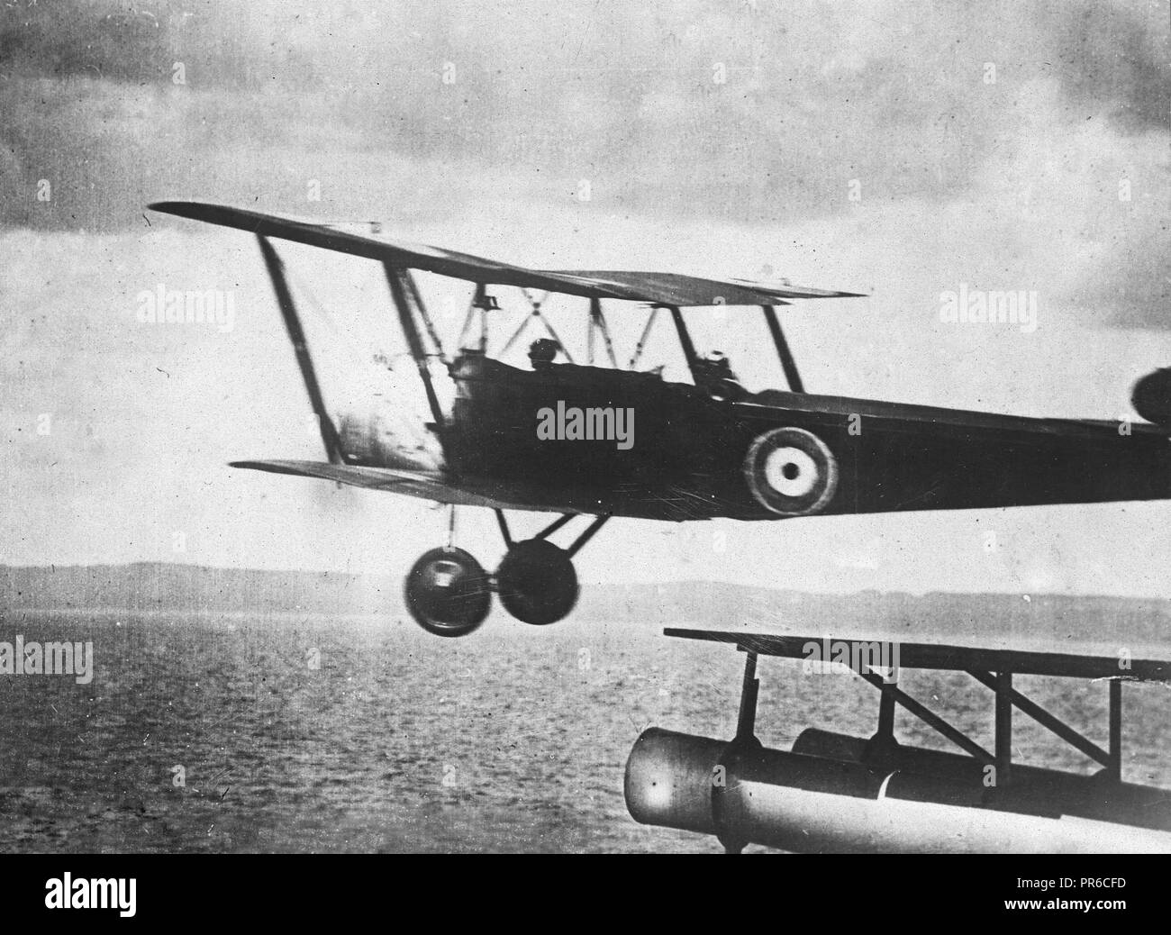 This remarkable photograph shows a British aeroplane leaving its rendezvous aboard battleship in search of undersea craft Stock Photo