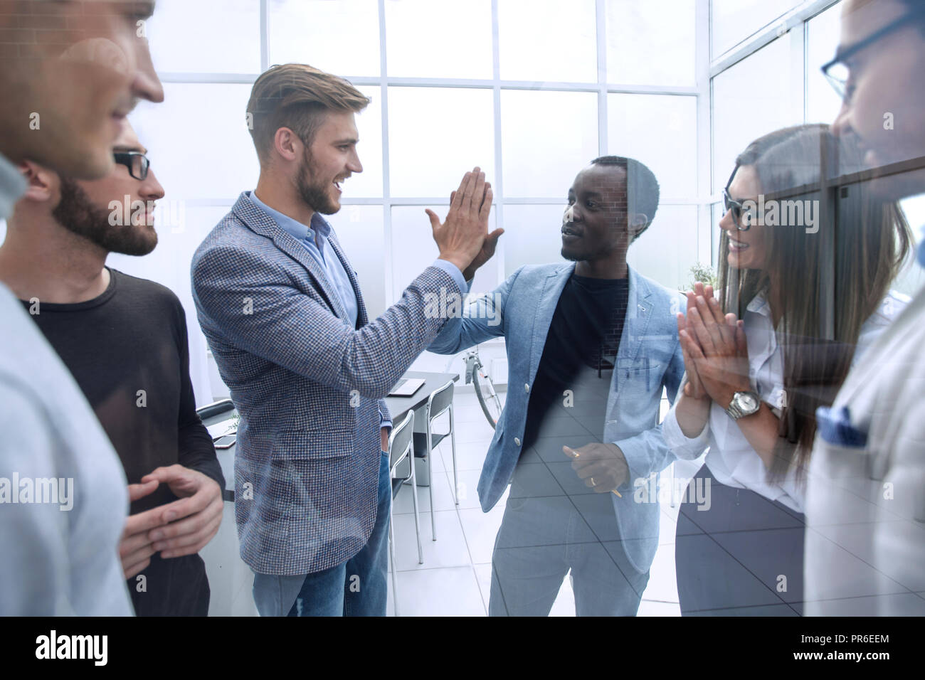 happy colleagues giving each other a high five Stock Photo - Alamy