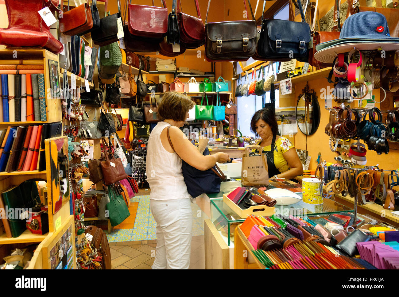 Woman shopping for leather goods in an italian shop; Montalcino, Tuscany Italy Europe Stock Photo