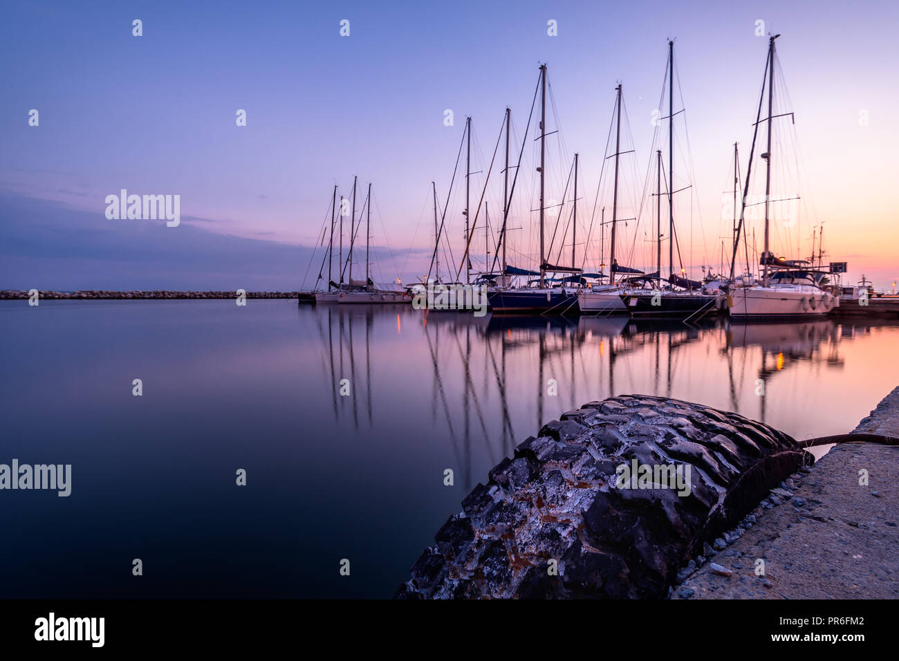 View of sail boats and reflections at the marina, during blue hour ...
