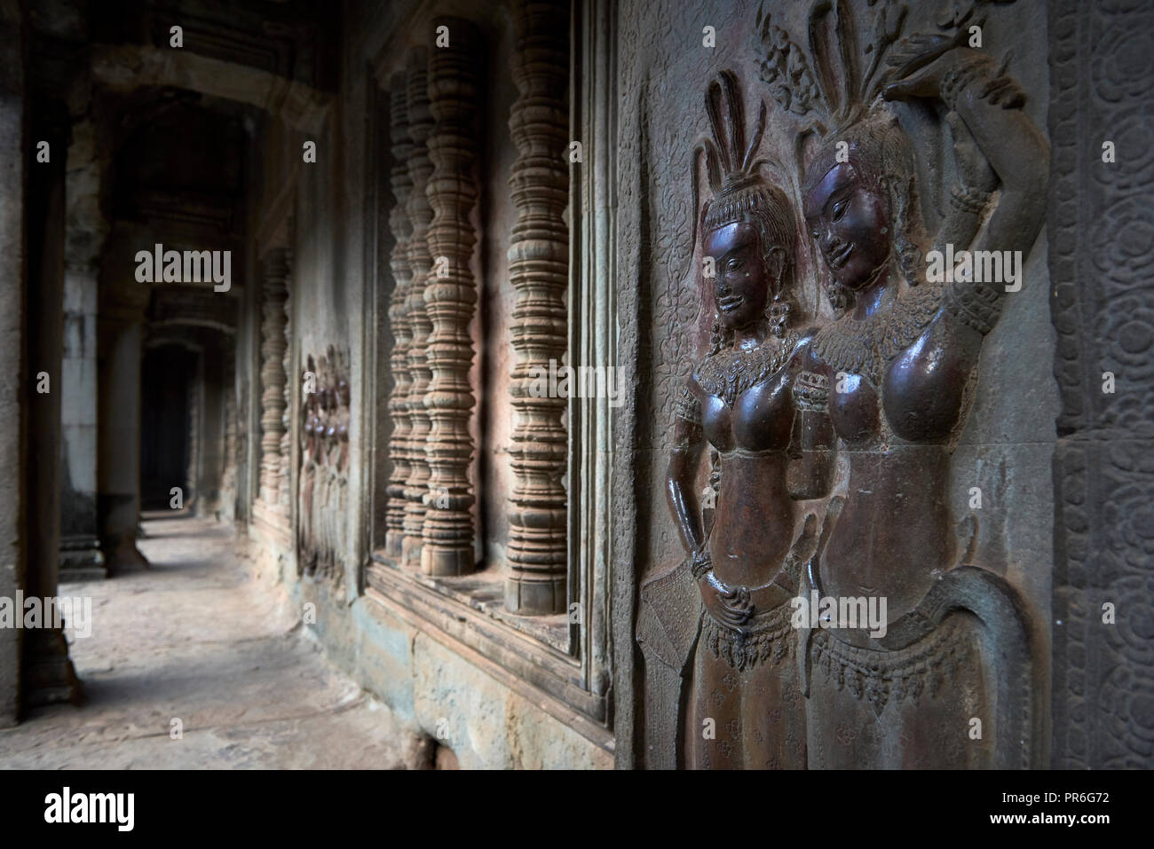 Corridor with dancers carved onto stone wall in Angkor Wat. The Angkor Wat complex, Built during the Khmer Empire age, located in Siem Reap, Cambodia, Stock Photo