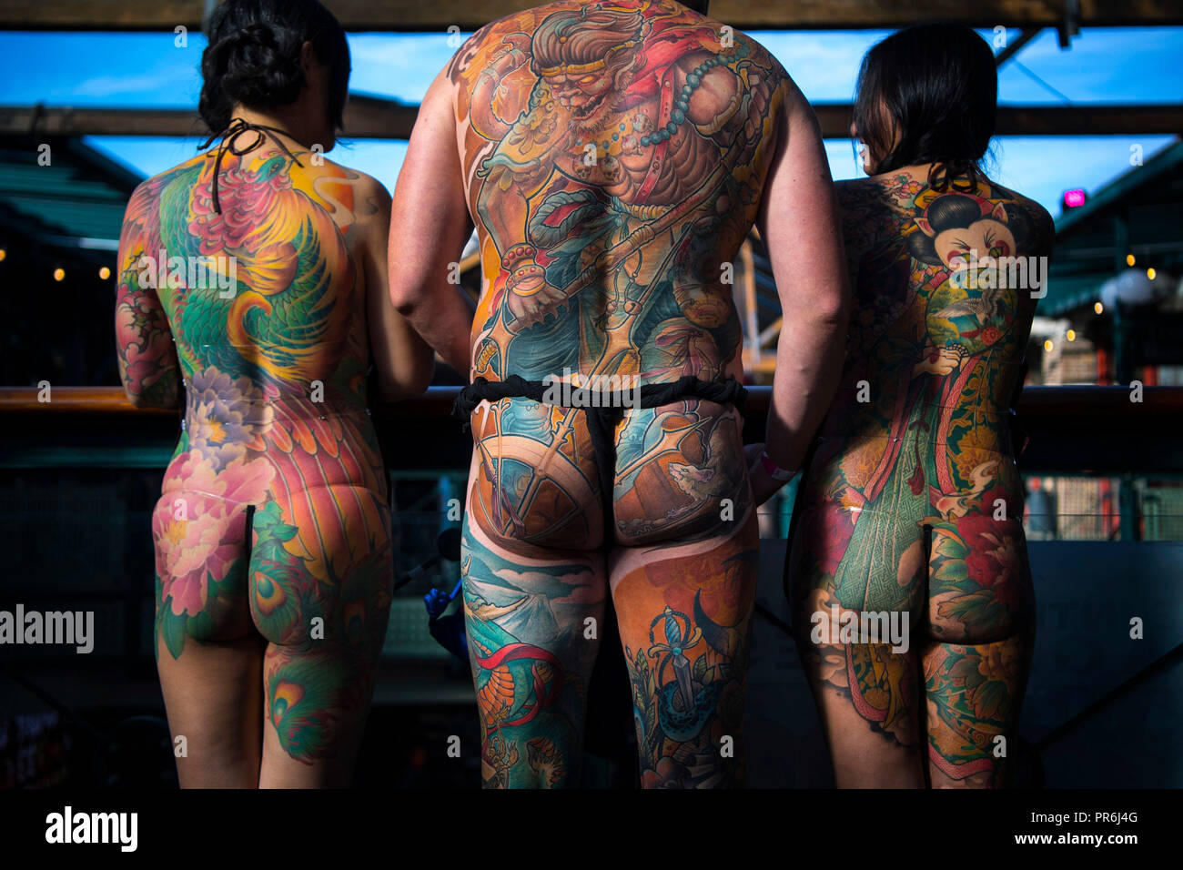 People show off their tattoos during the International tattoo convention at Tobacco Dock in east London. Stock Photo