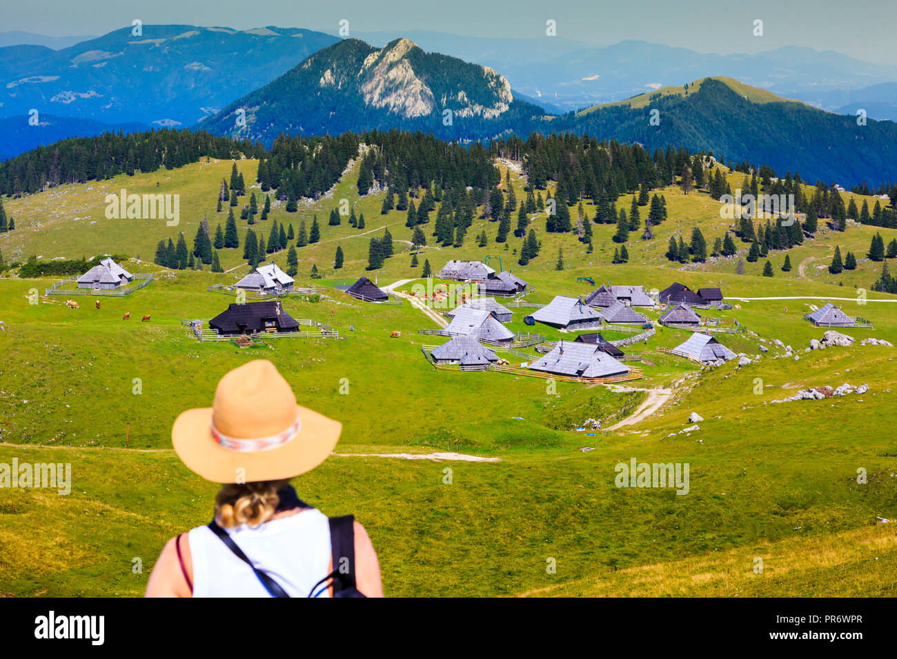 Mountains in summer with woman and huts. Stock Photo