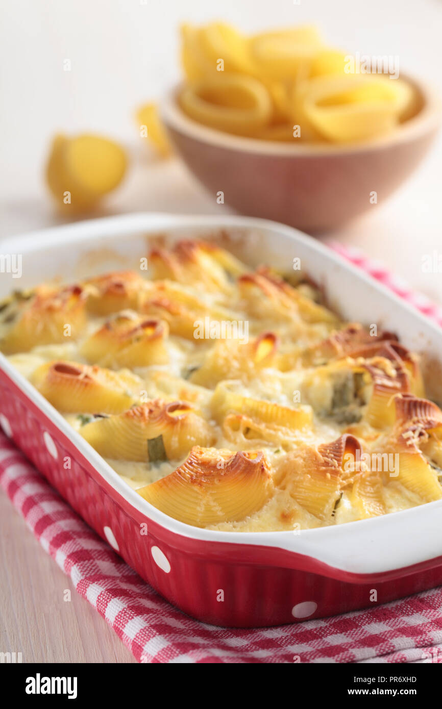 Baked lumaconi with spinach under bechamel sauce Stock Photo