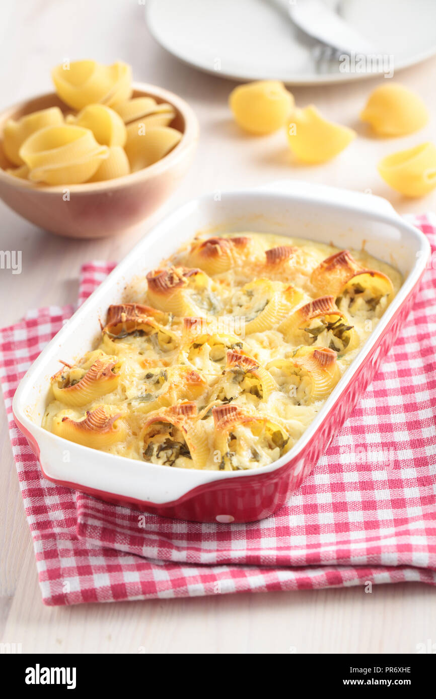 Baked lumaconi with spinach under bechamel sauce Stock Photo