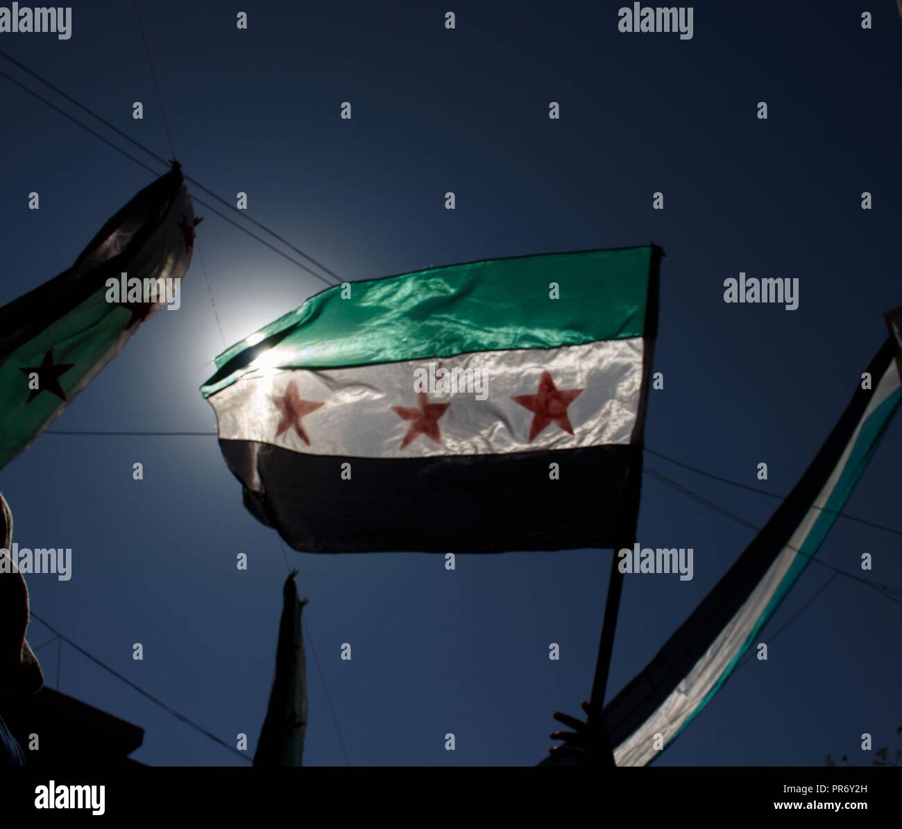 A flag seen being raised during a protest in the town of Eriha in Idlib calling for the release of detainees held by the Syrian regime. Stock Photo