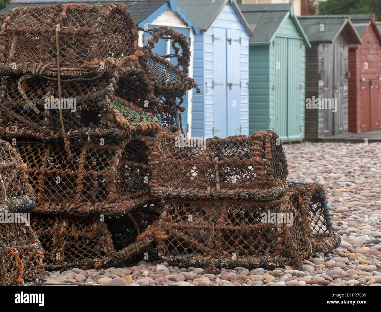 Crab creels and beach huts on the beach at Budleigh Salterton, East Devon, UK. Fishing and tourism, essential industries. Stock Photo