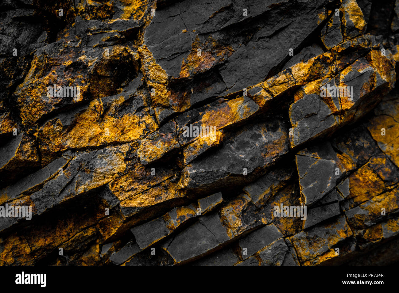 black rock background with gold  / yellow colored rocks - Stock Photo
