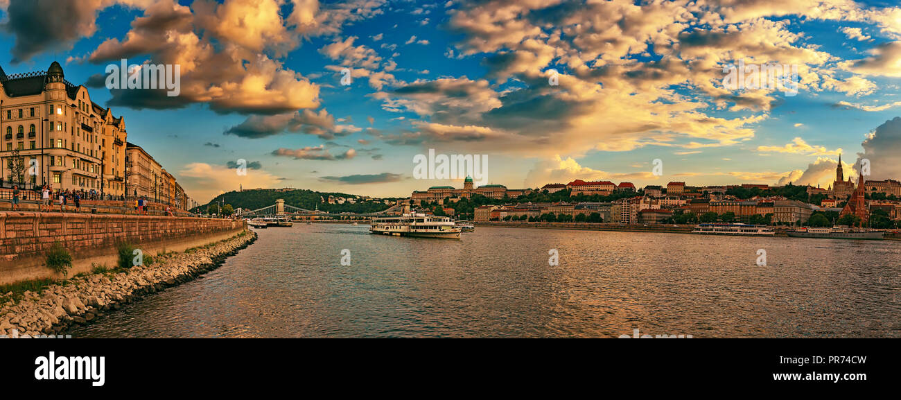 Beautiful Szechenyi Chain Bridge with sightseeing boat on River Danube and Buda Castle Royal Palace on sunset Stock Photo
