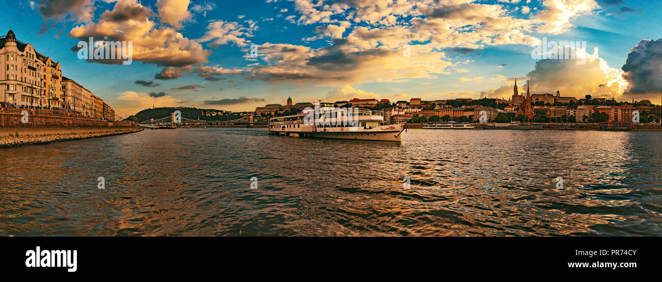 Beautiful Szechenyi Chain Bridge with sightseeing boat on River Danube and Buda Castle Royal Palace on sunset Stock Photo