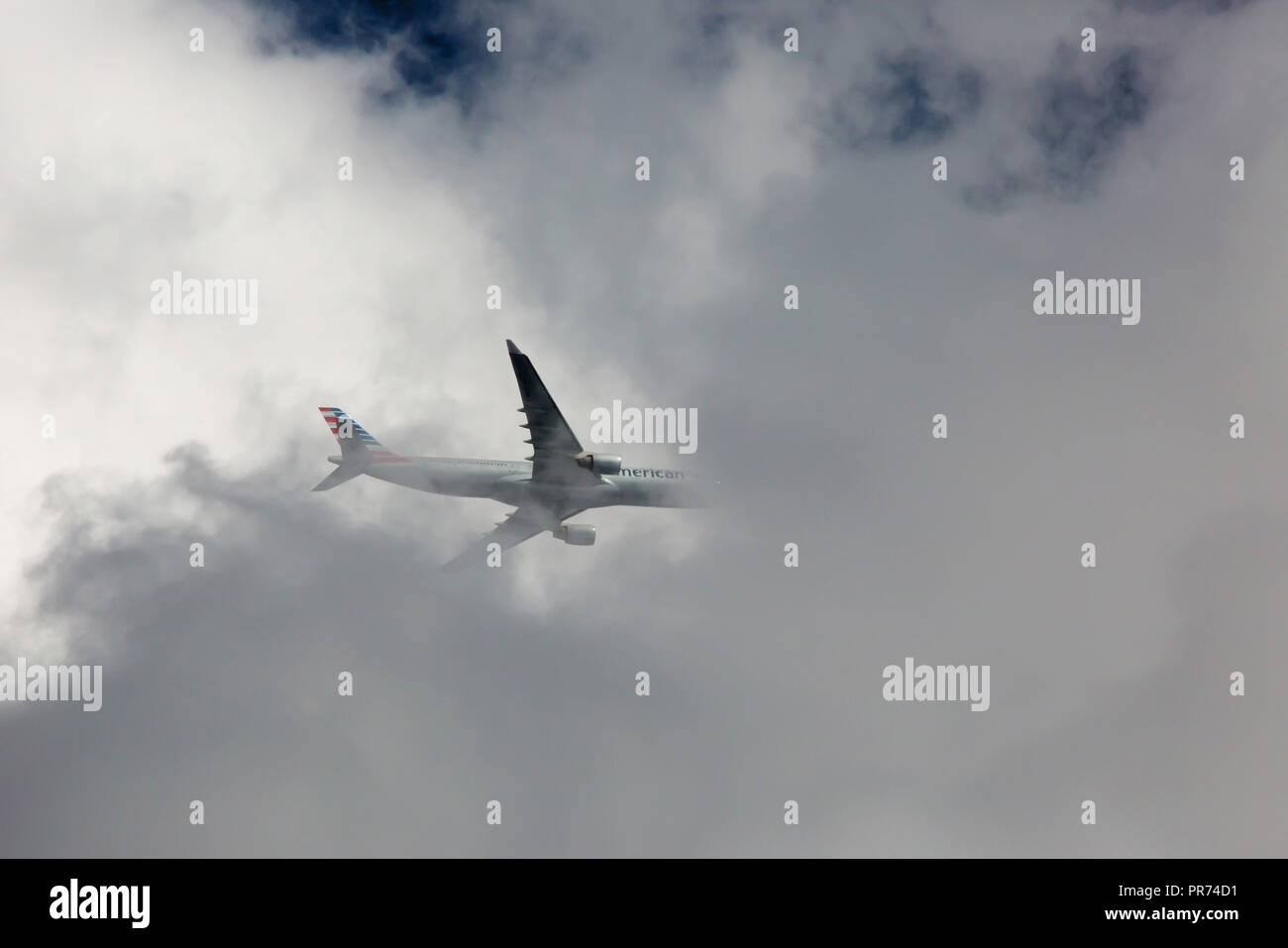 CHARLOTTE, NC (USA) - September 29, 2018: An American Airlines commercial jet navigates through storm clouds as it approaches an airport. Stock Photo