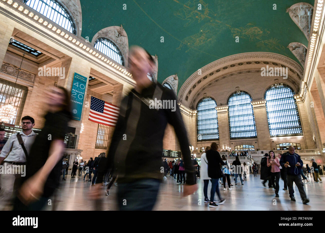 Travelers walk through Grand Central Terminal in New York City. Stock Photo
