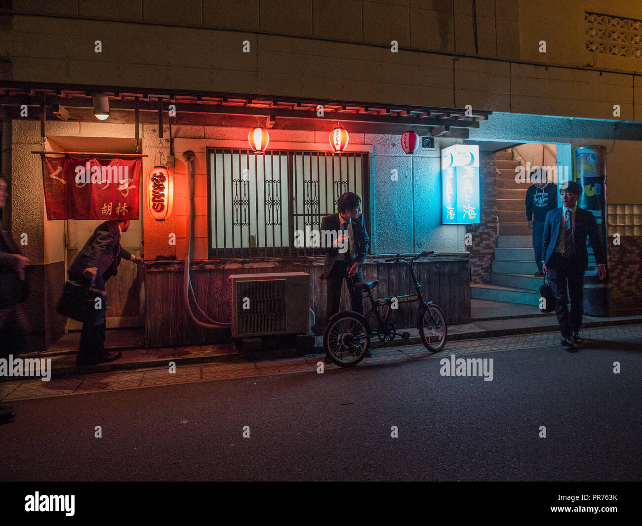 Salary men in street outside hostess club, entertainment district at night, Bungotakeda, Oita, Kyushu, Japan Stock Photo