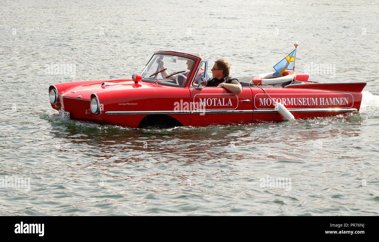 Motala, Sweden - Auguist 8, 2015: One red Amphicar with two persons  driving in the water. Stock Photo