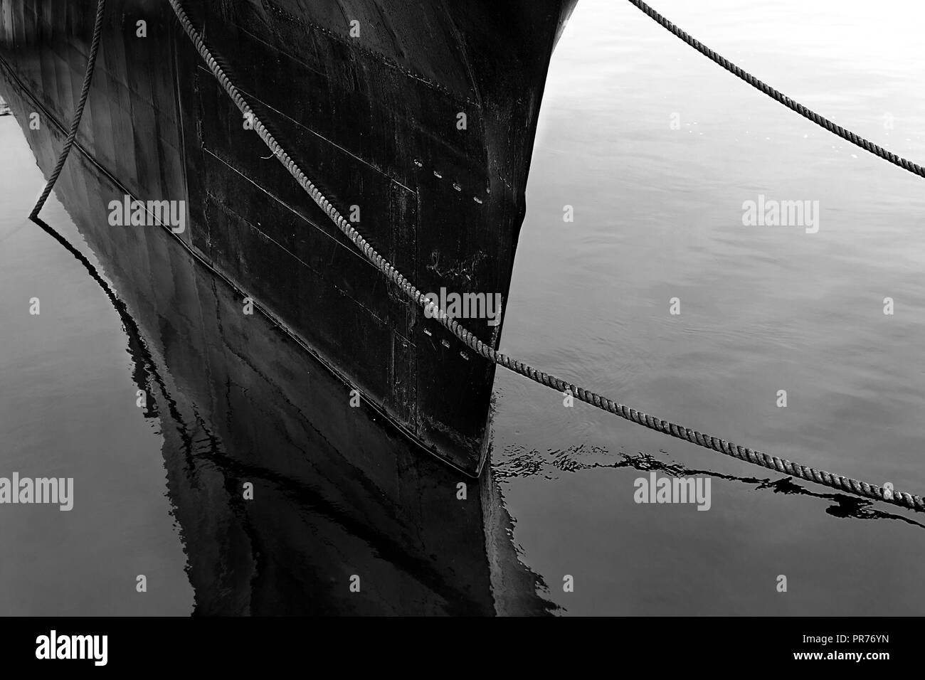 Very minimalistic picture in black and white showing a large submarine docked in the river Stock Photo