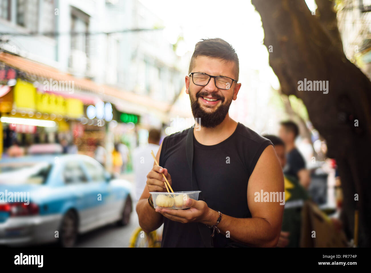 Foreigner eating baozi on the street in China Stock Photo