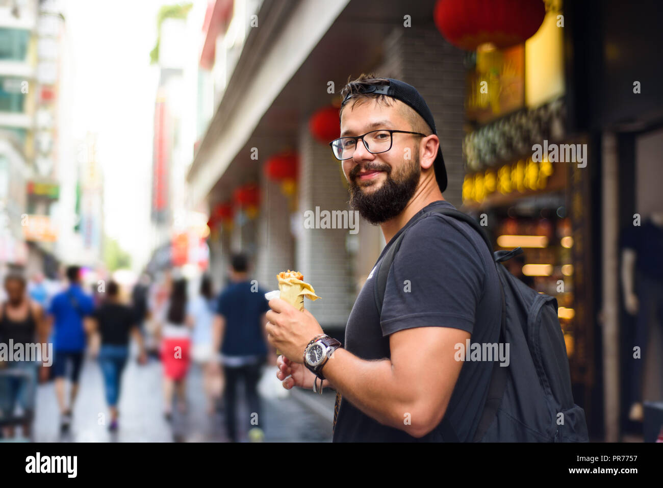 Foreigner eating Chinese street food on the street Stock Photo