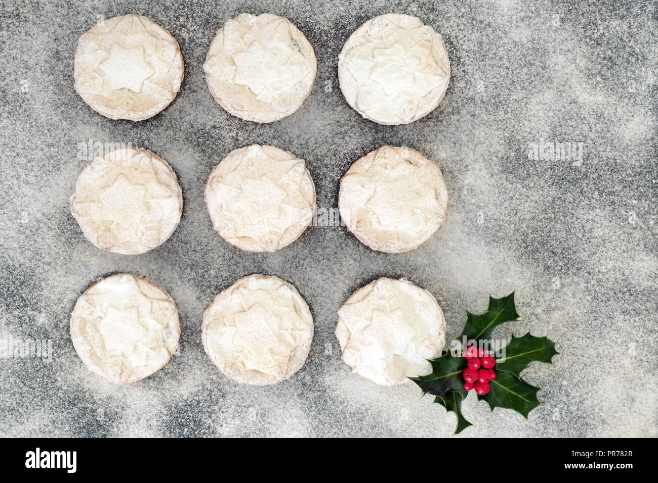 Christmas mince pies with icing sugar dusting and holly berry leaf ...
