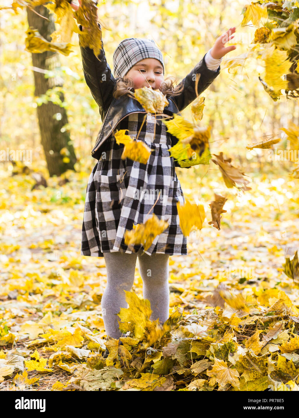 Fall, childhood and season concept - Little girl playing in the autumn ...