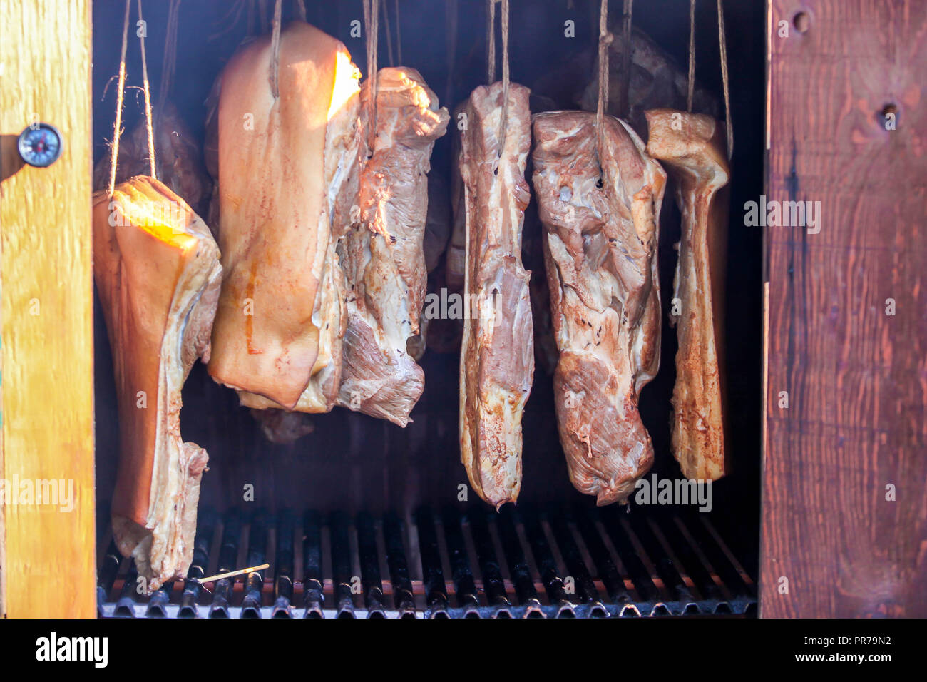 Smoked bacon hanging in wooden smoker Stock Photo