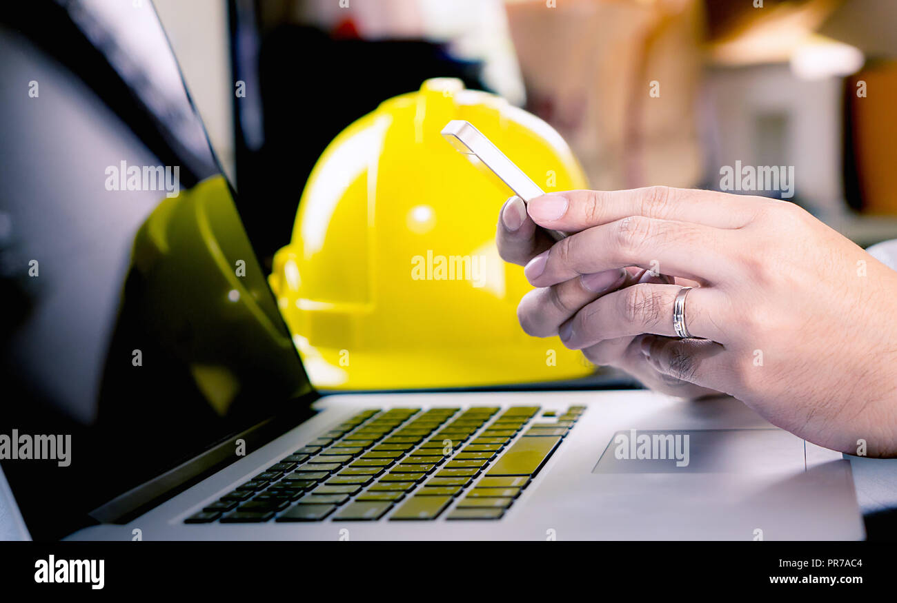 Engineer is using mobile phone in office Stock Photo