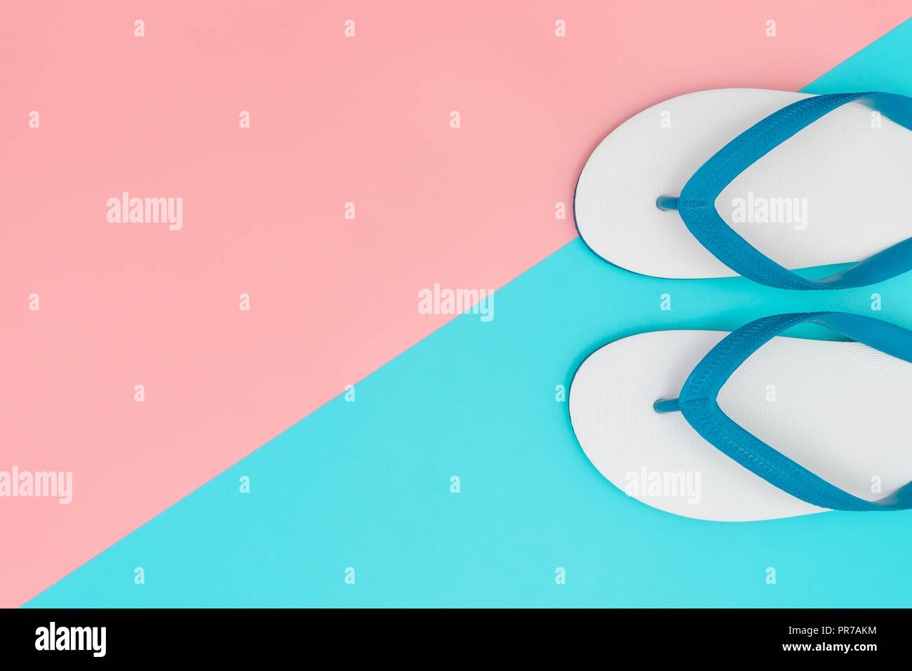 White rubber beach sandals on blue and pink copy space Stock Photo