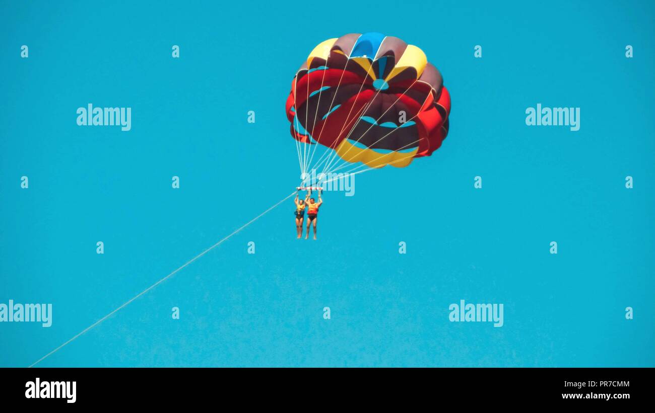 two parachutist in the sky flying under one common parachute, they pull