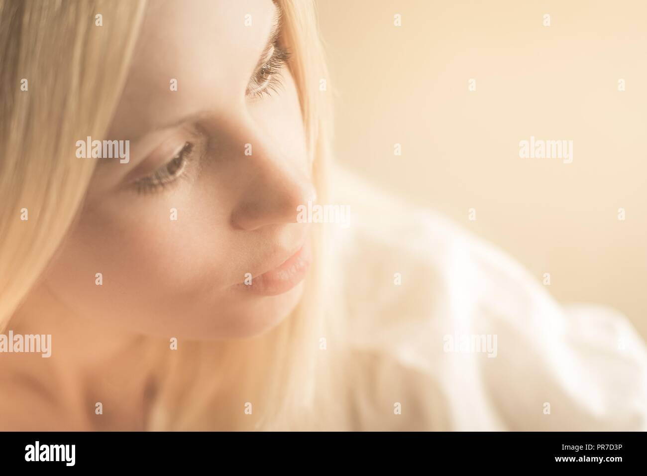 close-up portrait in a profile of a blonde girl with a pensive look aside Stock Photo
