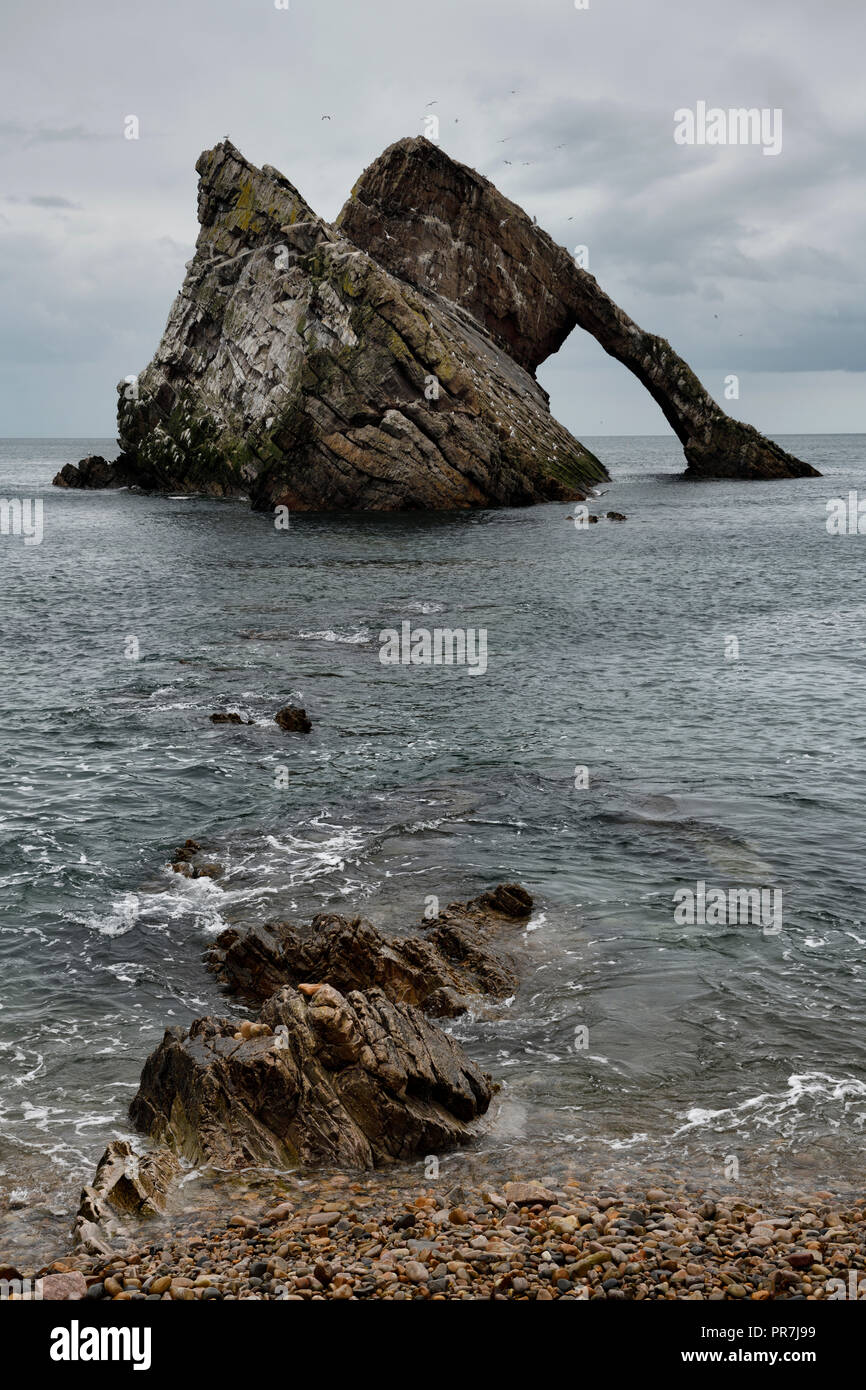 Bow Fiddle Rock quartzite sea arch from pebble beach at Portknockie on the North Sea Atlantic ocean Scotland UK Stock Photo