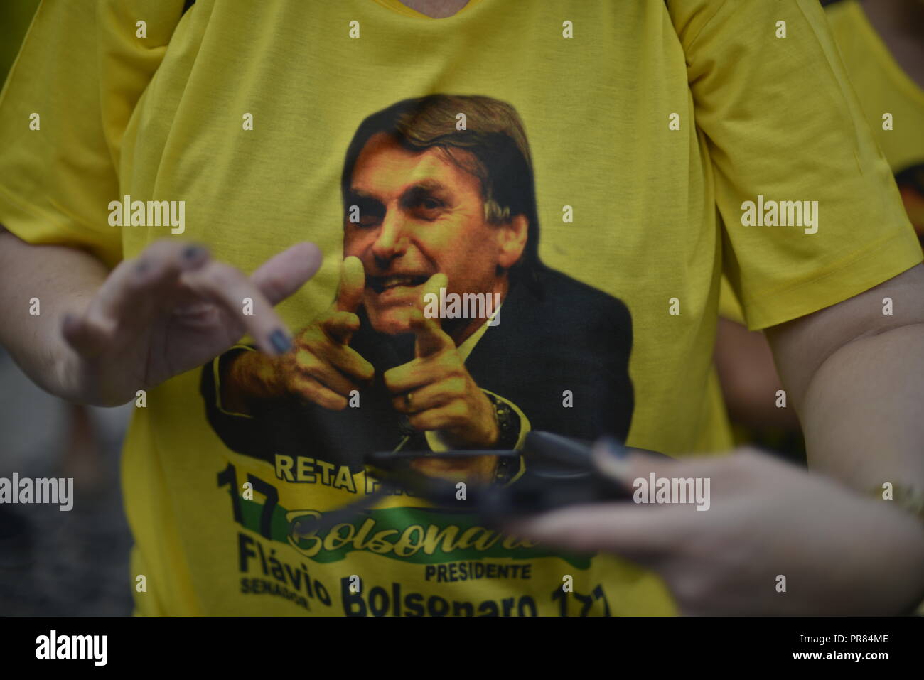 Rio de Janeiro, Brazil. 29th Sep, 2018. A supporter of the ultra-right presidential candidate Bolsonaro is wearing a T-shirt with his picture on it at a rally. The ex-military rants against homosexuals and blacks and glorifies the military dictatorship (1964-1985). Again and again he shocks with derailments. He once certified to a politician that she did not deserve to be raped 'because she is very ugly'. Credit: Fabio Teixeira/dpa/Alamy Live News Stock Photo