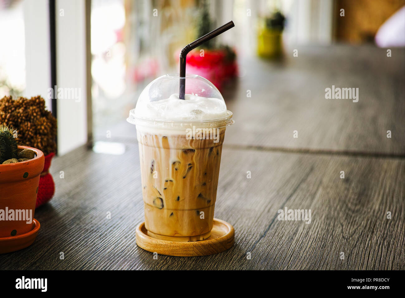 Cold Iced Coffee in plastic glass on table in the coffee cafe Stock Photo