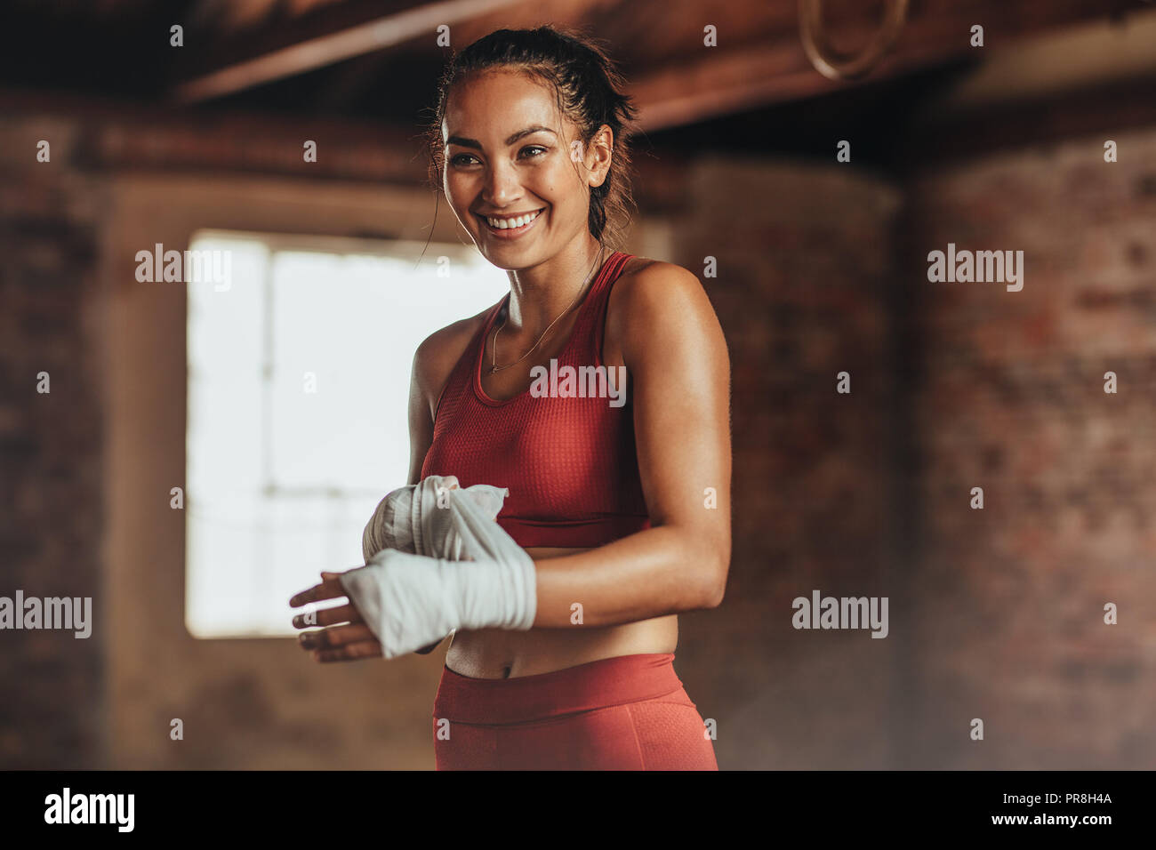 Woman boxer wearing strap on wrist for boxing practice. Fitness female