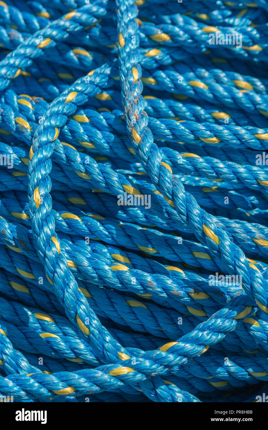 Harbour scenes around Newquay, Cornwall. Coiled commercial marine rope on harbour quayside. Metaphor tangled up, in a tangle, given enough rope. Stock Photo