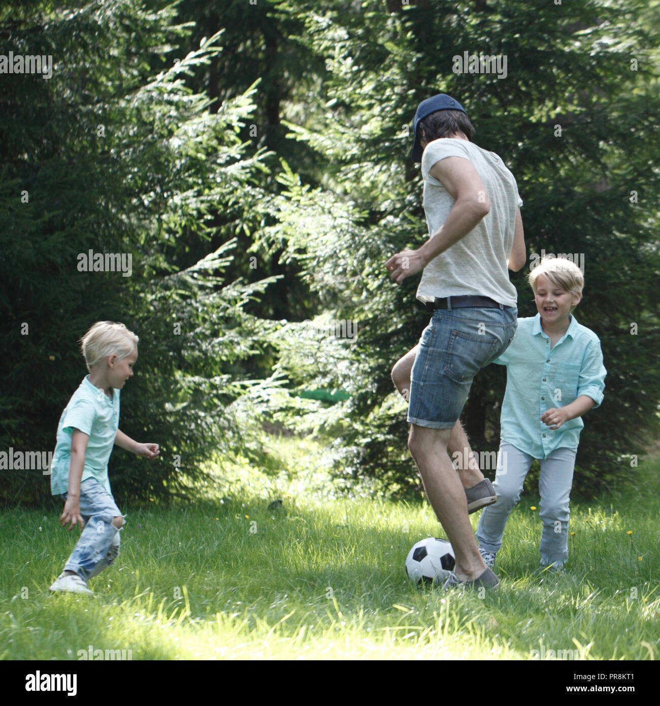 Happy children playing football in summer park Stock Photo - Alamy