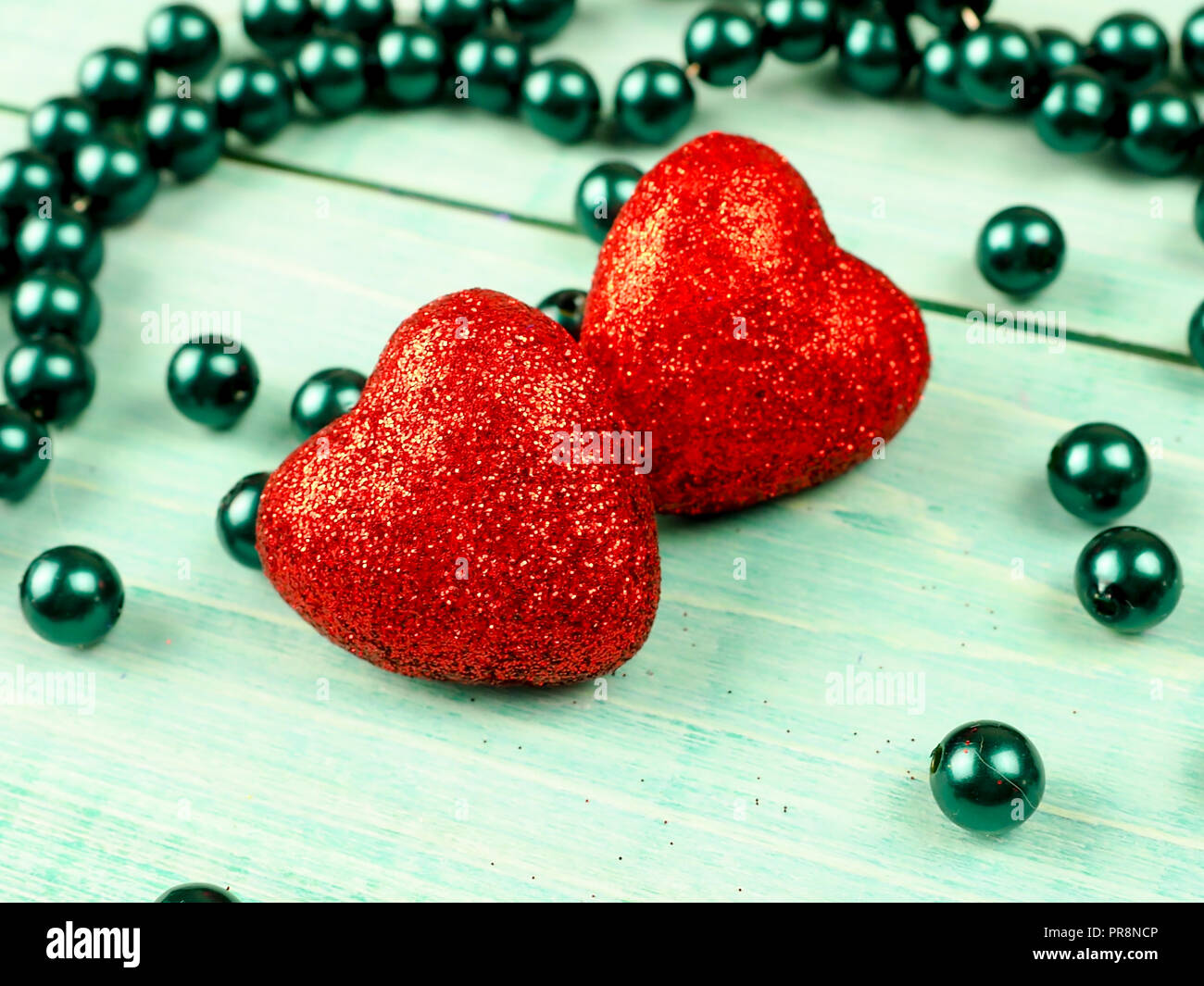 little red shiny hearts on blue background Stock Photo - Alamy