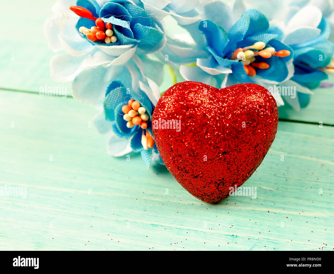 little red shiny hearts on blue background Stock Photo - Alamy