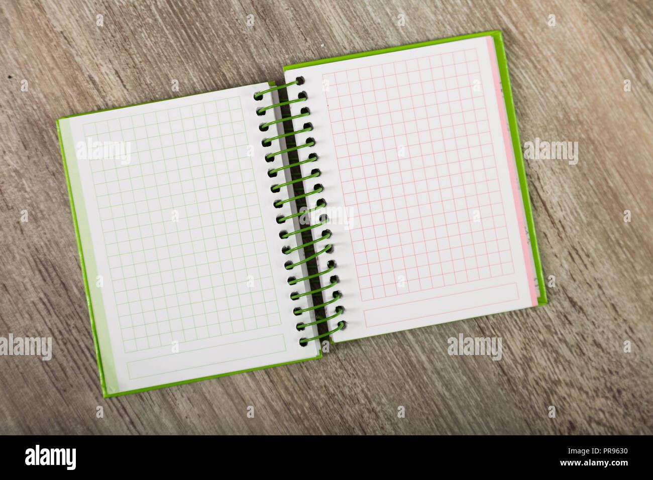 Open notebook lying on wooden surface Stock Photo