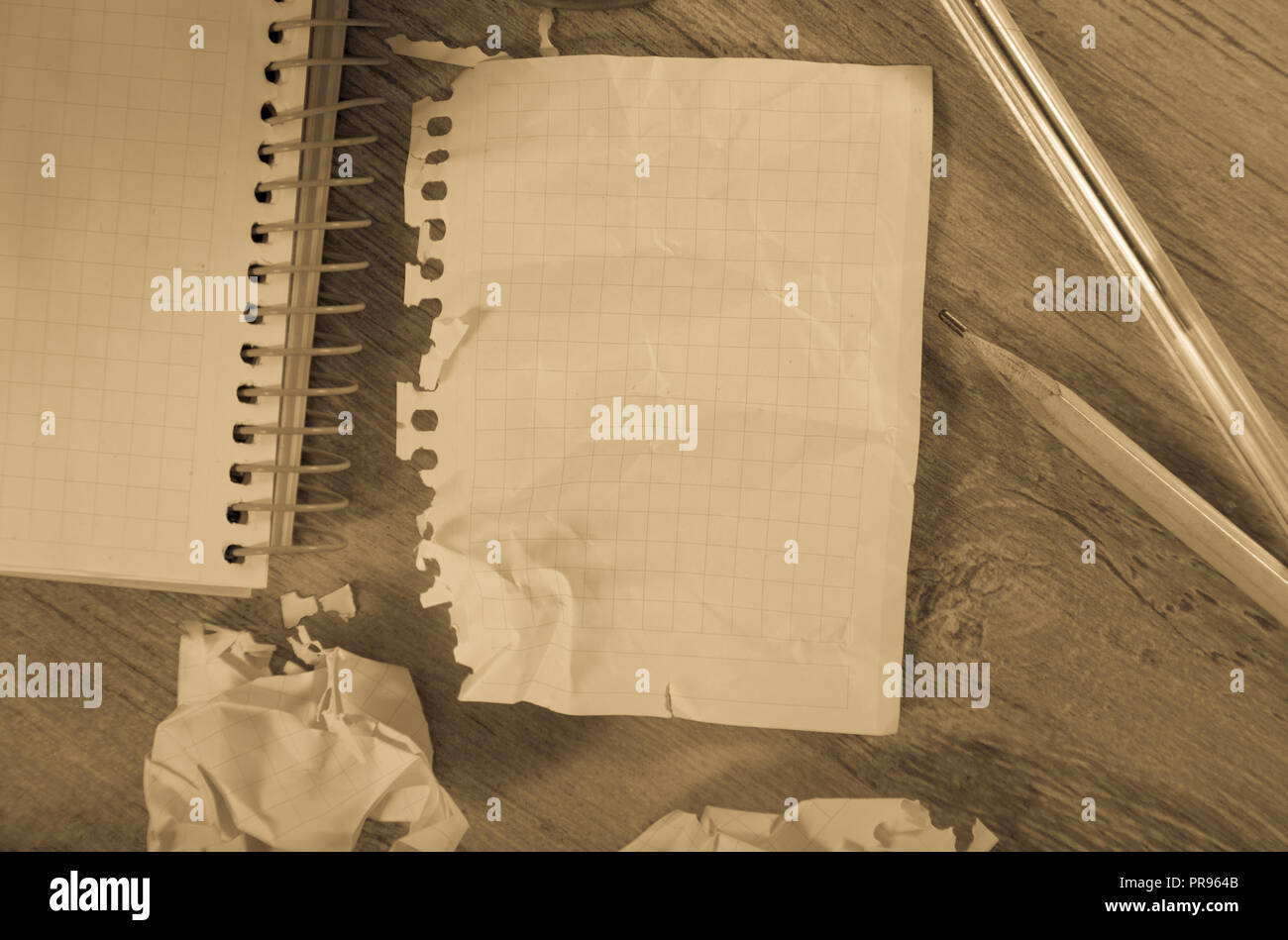 Crumpled empty pages and notebook lying on wooden surface Stock Photo