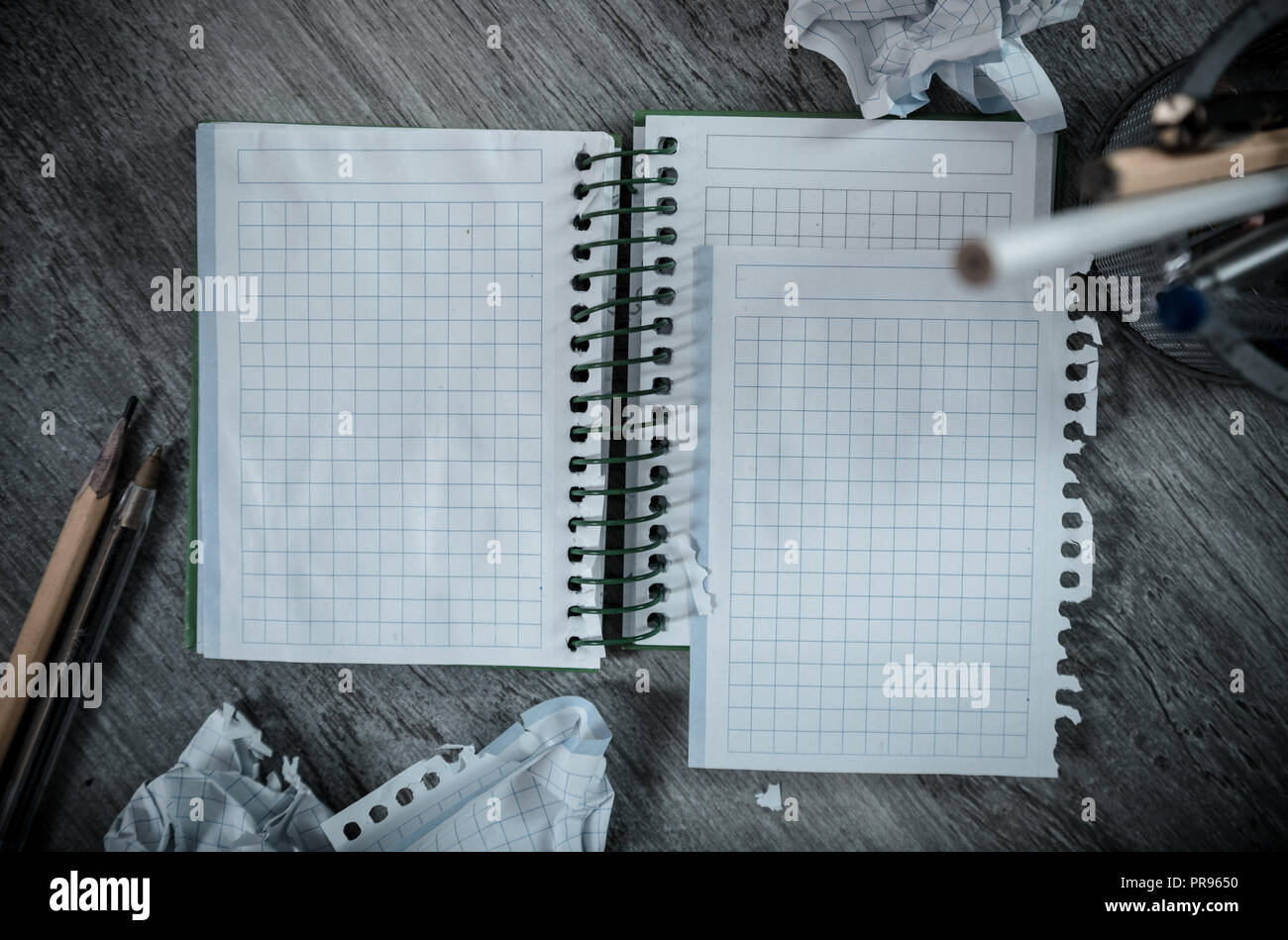 Crumpled empty pages and notebook lying on wooden surface Stock Photo